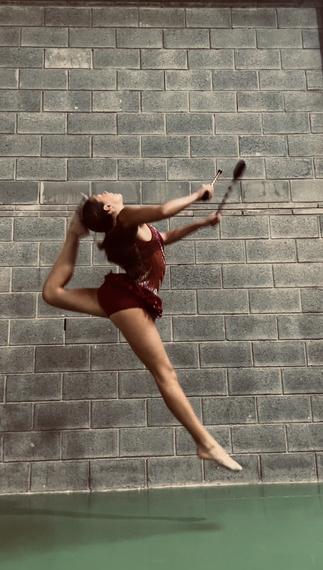 Gimnasta de Nexa fent un salt amb maces